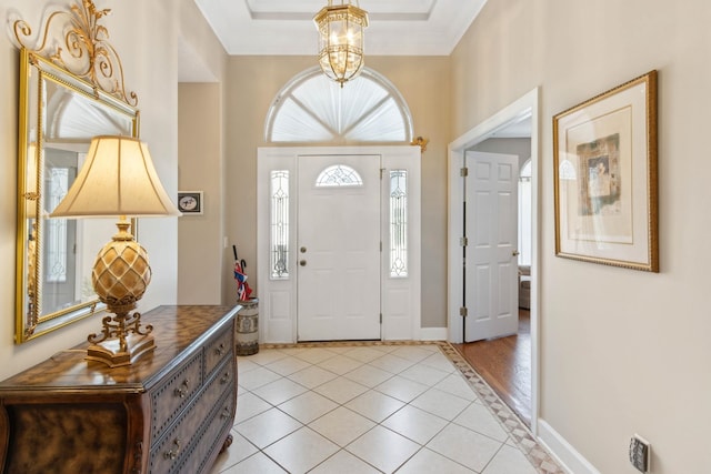 613 Wild Bird Ln, Saint Augustine, FL 32080 - entrance foyer with light tile patterned flooring, a chandelier, baseboards, and a raised ceiling