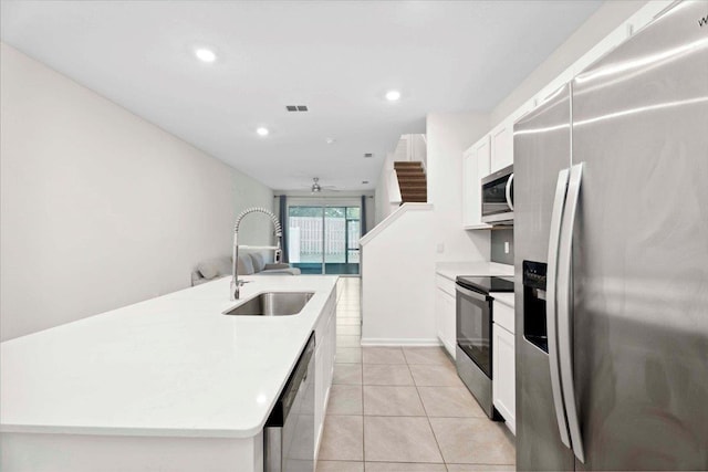 180 Stonegate Ave, Saint Augustine, FL 32084 - kitchen with stainless steel appliances, a sink, light countertops, ceiling fan, and white cabinetry