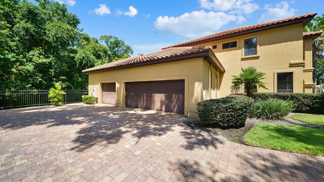 84 Villa Sovana Ct, Saint Johns, FL 32259 - view of property exterior featuring stucco siding, a tiled roof, an attached garage, and driveway