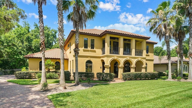 84 Villa Sovana Ct, Saint Johns, FL 32259 - mediterranean / spanish home featuring a balcony, a tiled roof, stucco siding, and a front yard