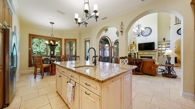 84 Villa Sovana Ct, Saint Johns, FL 32259 - kitchen featuring a chandelier, stainless steel fridge, light stone countertops, decorative light fixtures, and ornamental molding