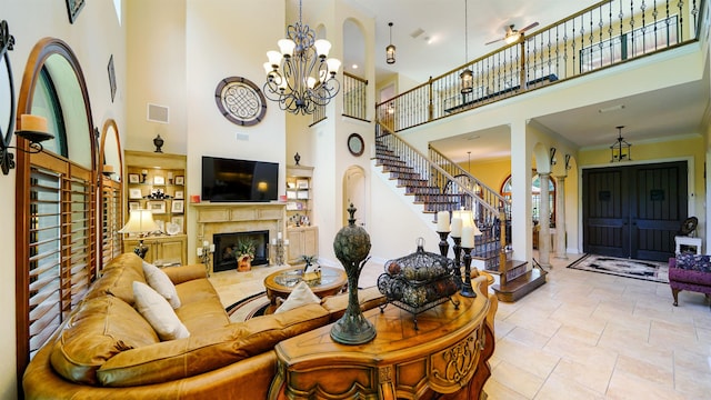 84 Villa Sovana Ct, Saint Johns, FL 32259 - living room with a towering ceiling, a premium fireplace, stairs, a chandelier, and a ceiling fan
