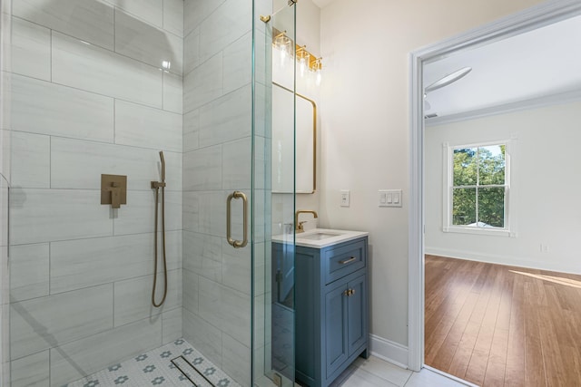 bathroom with walk in shower, vanity, wood-type flooring, and ornamental molding