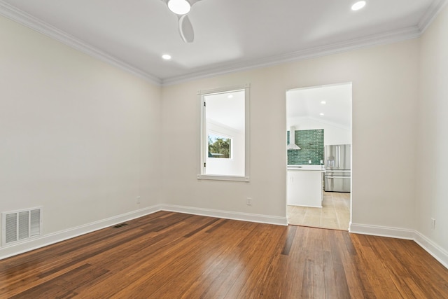 unfurnished room featuring lofted ceiling, light hardwood / wood-style floors, ceiling fan, and crown molding