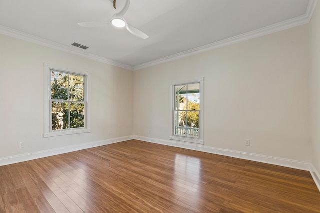 empty room with crown molding, ceiling fan, a healthy amount of sunlight, and wood-type flooring