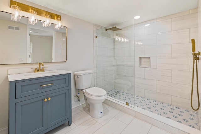 bathroom featuring tiled shower, vanity, and toilet