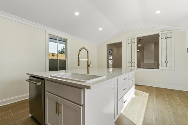 kitchen featuring a kitchen island with sink, sink, lofted ceiling, and light wood-type flooring