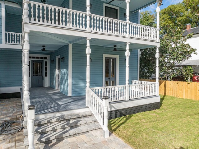 property entrance featuring french doors, a yard, a balcony, and ceiling fan