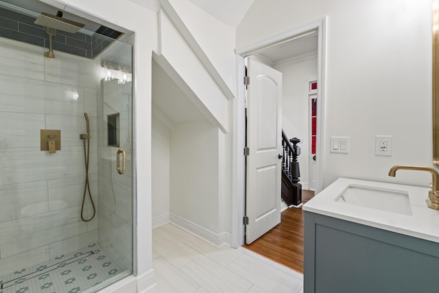 bathroom featuring lofted ceiling, vanity, hardwood / wood-style flooring, and a shower with shower door