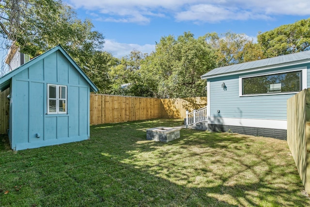 view of yard with a shed and an outdoor fire pit