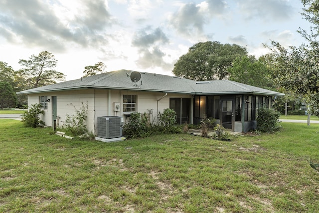 back of house featuring a yard, central AC unit, and a sunroom