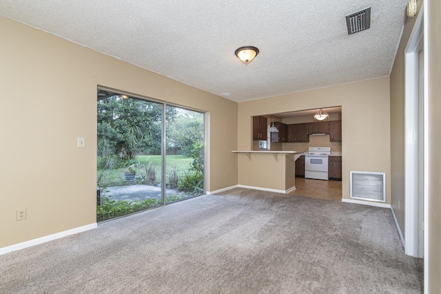 unfurnished living room featuring dark carpet and a textured ceiling