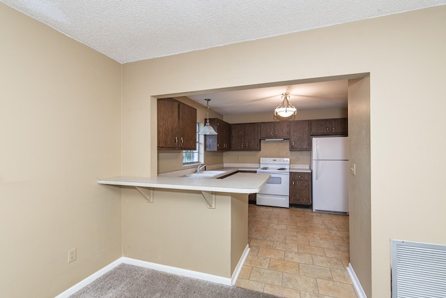 kitchen featuring kitchen peninsula, a breakfast bar, white appliances, sink, and pendant lighting