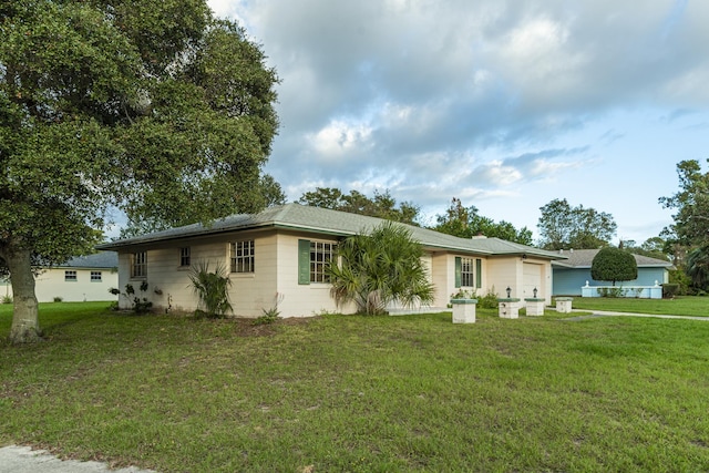 single story home with a garage and a front lawn