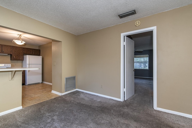 interior space featuring carpet floors, dark brown cabinetry, a breakfast bar, and white fridge