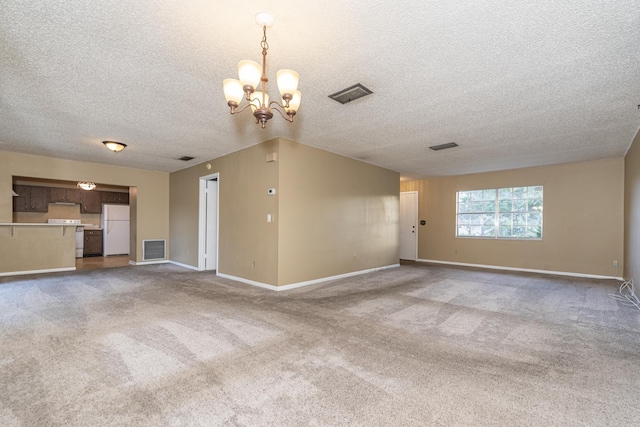 unfurnished living room featuring carpet flooring, a textured ceiling, and a notable chandelier