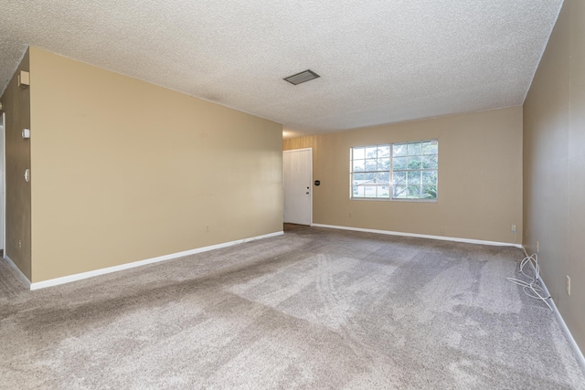 spare room with carpet and a textured ceiling