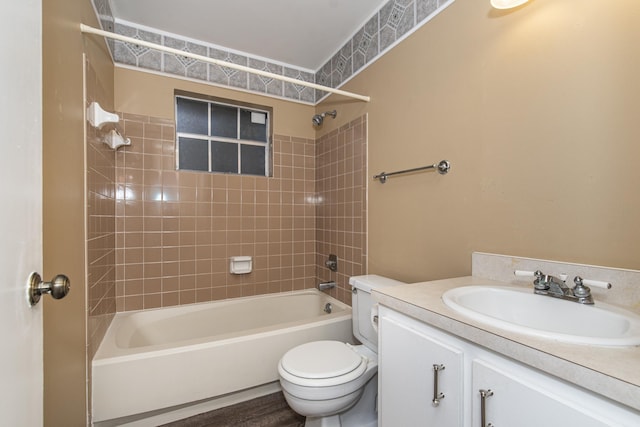 full bathroom featuring hardwood / wood-style flooring, vanity, toilet, and tiled shower / bath