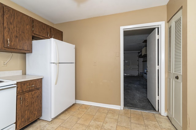 kitchen featuring dark brown cabinets and white appliances