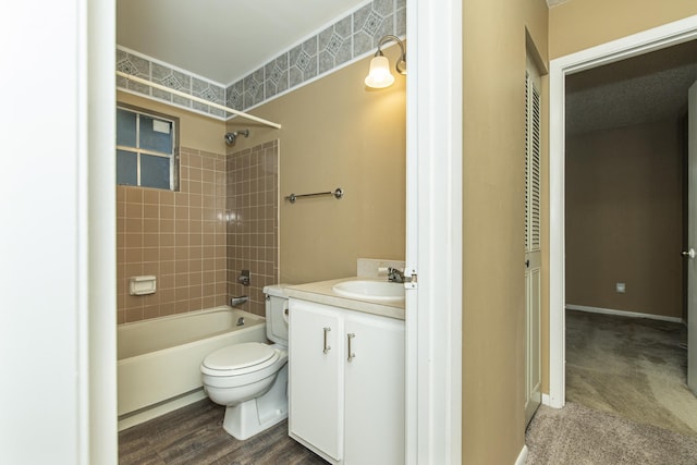 full bathroom featuring vanity, wood-type flooring, tiled shower / bath combo, and toilet