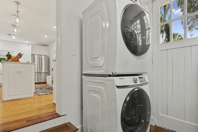 washroom featuring dark hardwood / wood-style floors and stacked washing maching and dryer