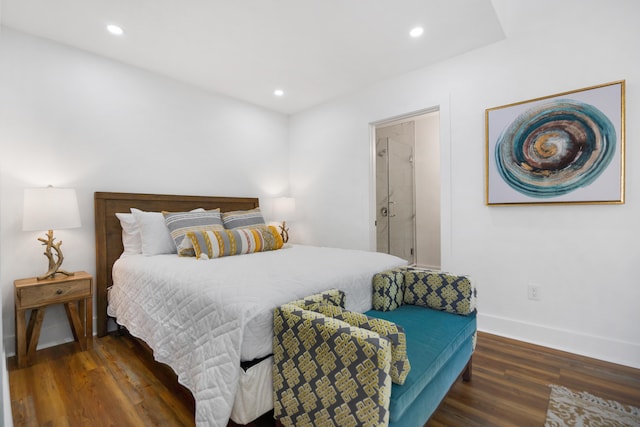 bedroom with dark hardwood / wood-style flooring and connected bathroom