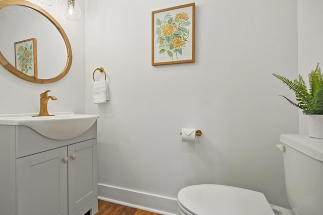 bathroom featuring vanity, wood-type flooring, and toilet