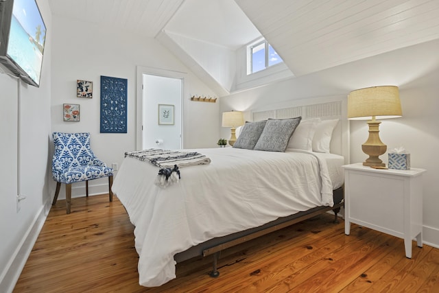 bedroom featuring wood-type flooring and vaulted ceiling