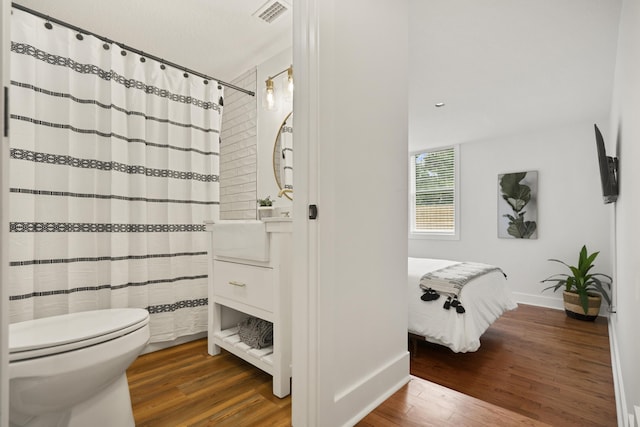 bathroom featuring wood-type flooring and toilet