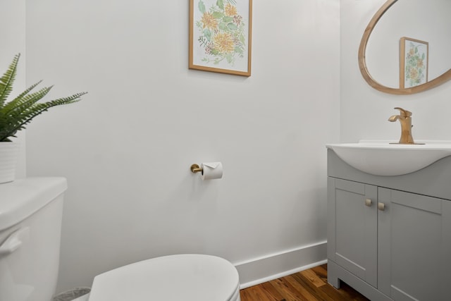 bathroom with vanity, hardwood / wood-style flooring, and toilet