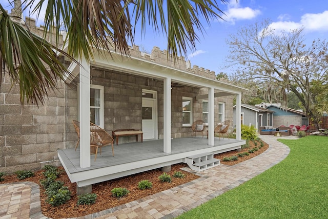 rear view of house featuring a wooden deck and a lawn