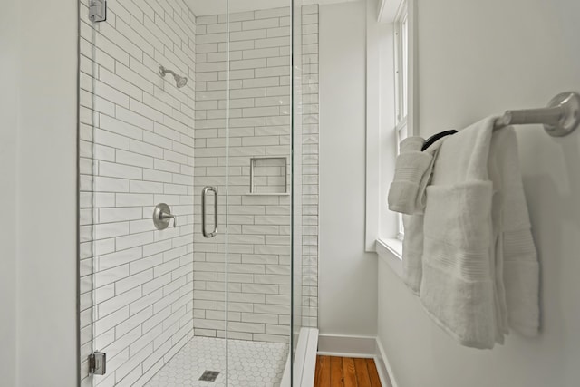 bathroom featuring hardwood / wood-style floors and a shower with shower door