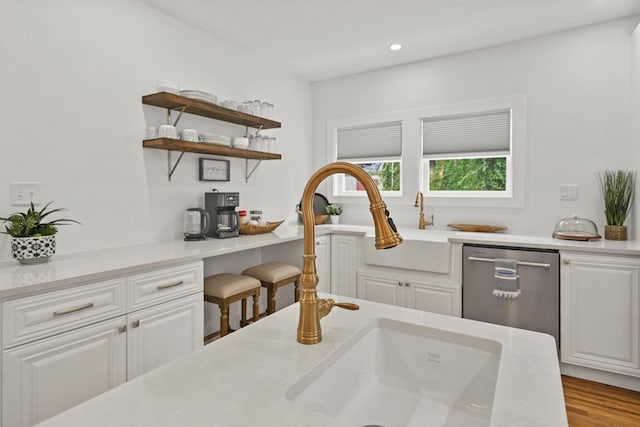 kitchen with dishwasher, light hardwood / wood-style flooring, and white cabinets