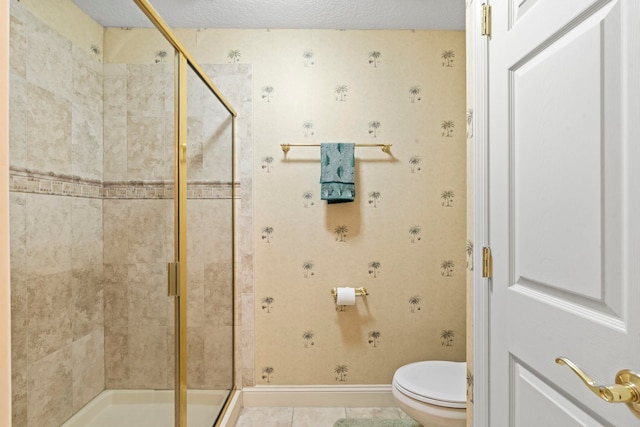 full bath with a textured ceiling, baseboards, toilet, and a shower stall