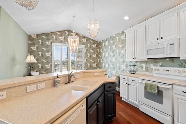 kitchen with white appliances, wallpapered walls, light countertops, and a sink