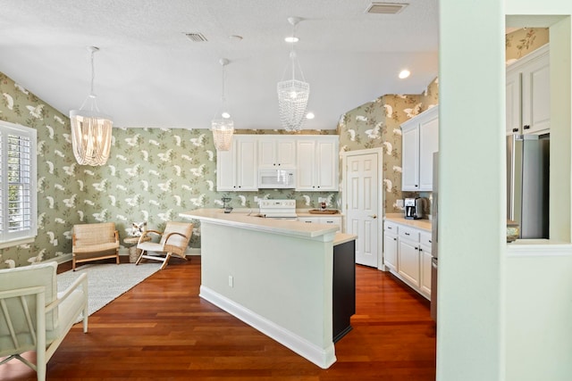 kitchen featuring wallpapered walls, pendant lighting, an island with sink, light countertops, and white microwave