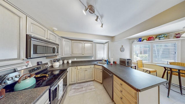 21 Mid Pines Cir Unit 21, Palm Coast, FL 32137 - kitchen featuring stainless steel appliances, a sink, dark countertops, and a peninsula