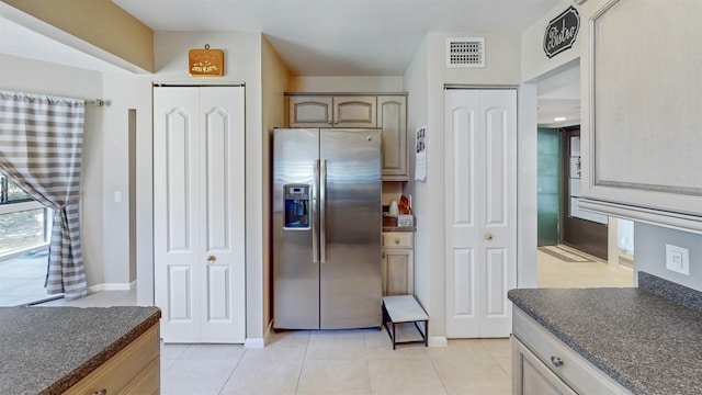 21 Mid Pines Cir Unit 21, Palm Coast, FL 32137 - kitchen with stainless steel refrigerator with ice dispenser, dark countertops, light tile patterned floors, and baseboards