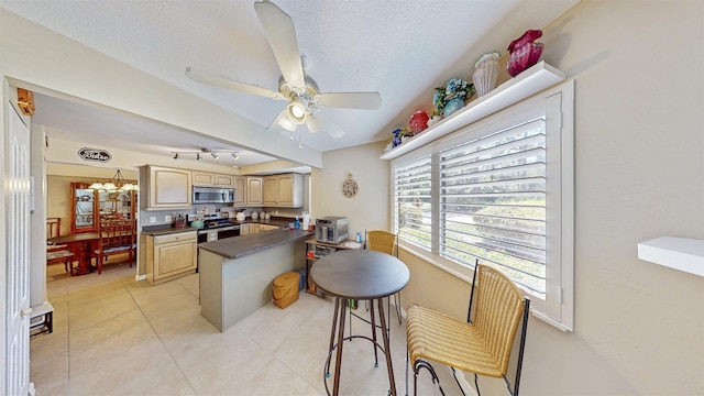 21 Mid Pines Cir Unit 21, Palm Coast, FL 32137 - kitchen featuring stainless steel appliances, dark countertops, a peninsula, a ceiling fan, and light tile patterned flooring