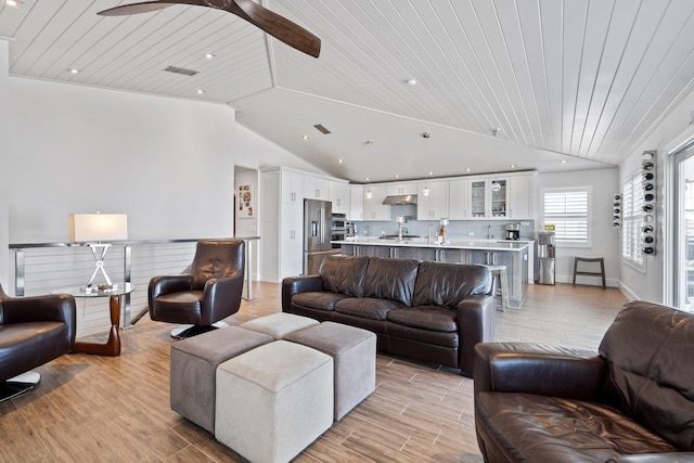 living area featuring light wood finished floors, visible vents, lofted ceiling, wooden ceiling, and ceiling fan