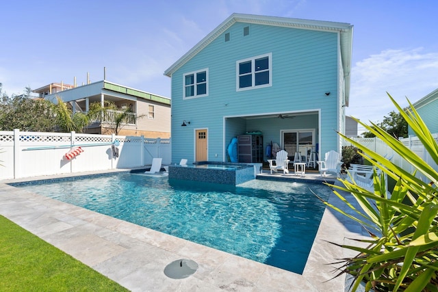 rear view of house with a pool with connected hot tub, a patio area, a fenced backyard, and ceiling fan