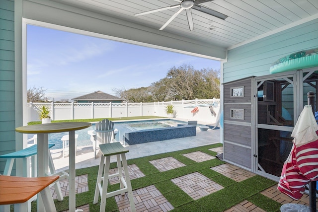 view of patio / terrace with a fenced backyard, a pool with connected hot tub, and ceiling fan