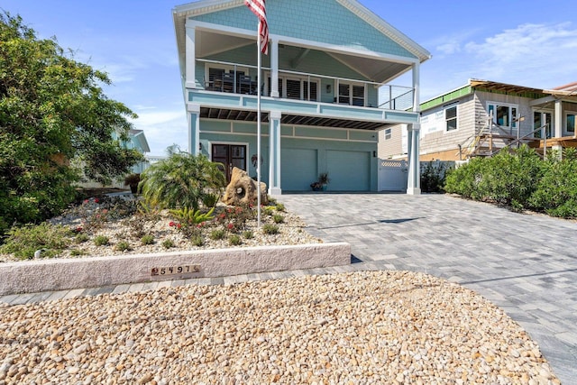 view of front of home with a garage, decorative driveway, and a balcony