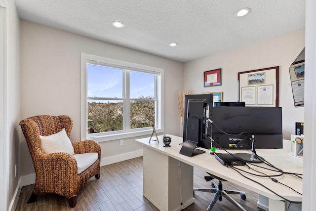 office space with a textured ceiling, recessed lighting, wood finished floors, and baseboards