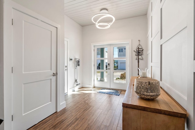 entryway with french doors, wooden ceiling, baseboards, and wood finished floors