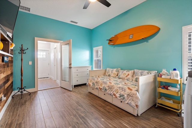 bedroom featuring a ceiling fan, visible vents, and wood finished floors