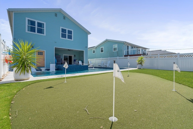 rear view of house with a fenced backyard, a fenced in pool, a ceiling fan, and a patio