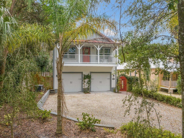 view of front of home with a garage, dirt driveway, a gate, and fence