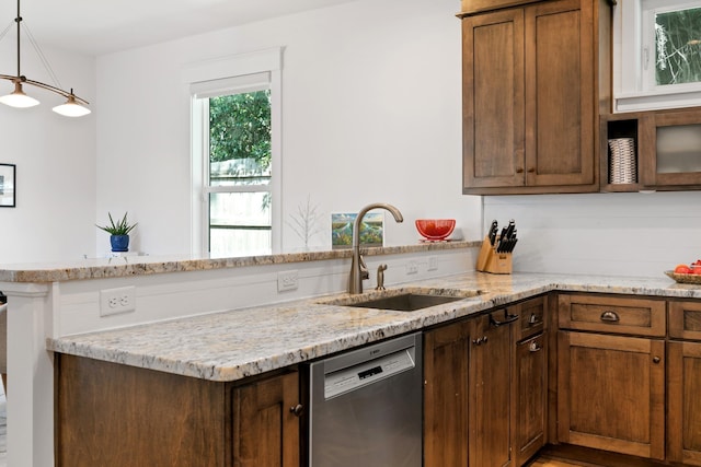 kitchen featuring a sink, a peninsula, dishwasher, and hanging light fixtures