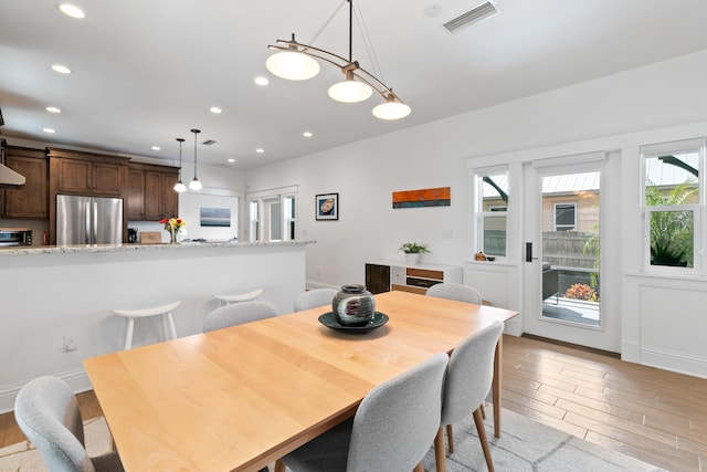 dining room with recessed lighting, baseboards, visible vents, and light wood finished floors